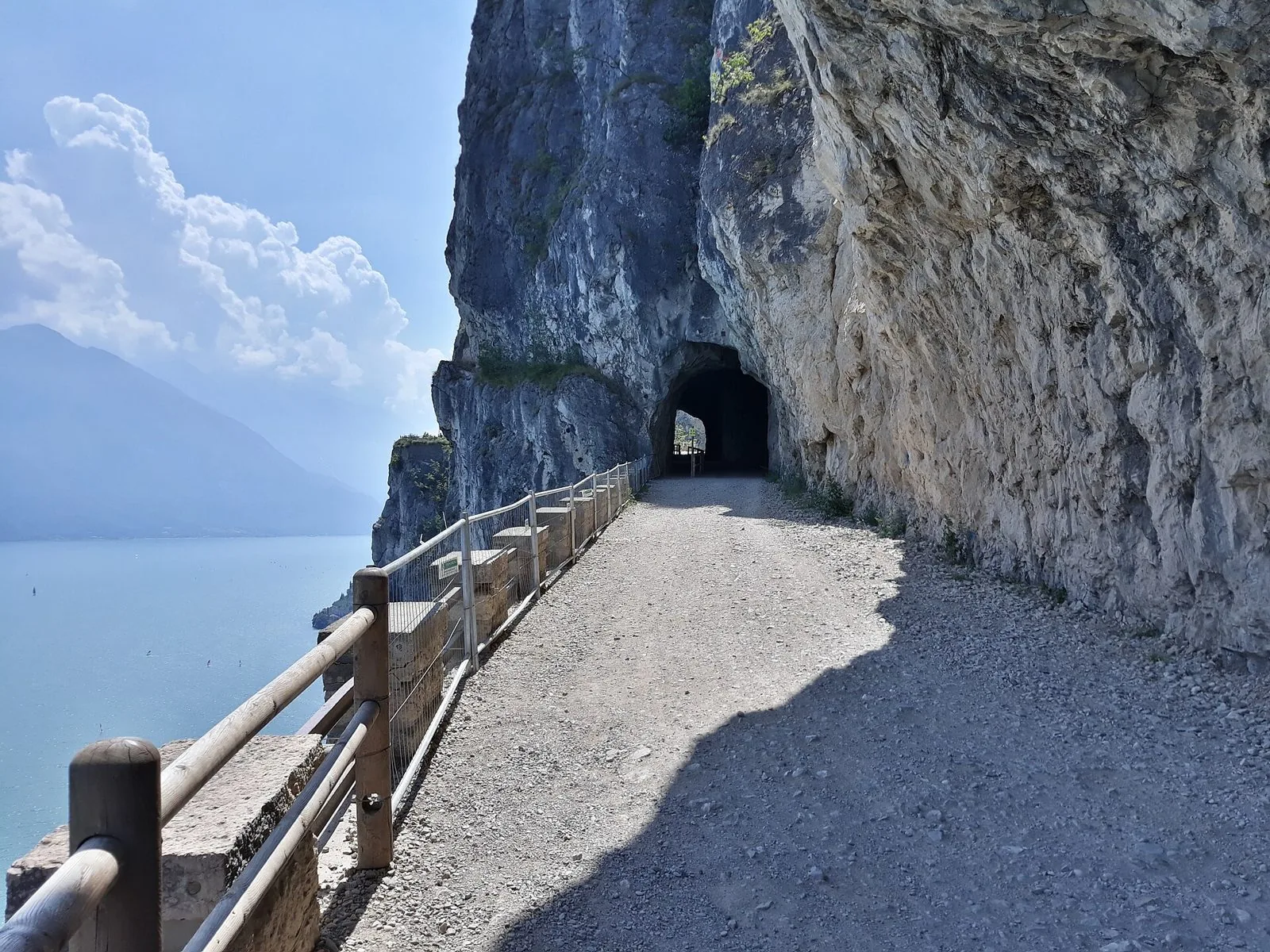 Sterrata panoramica della strada del Ponale scavata nella roccia a strapiombo sul Lago di Garda, con galleria